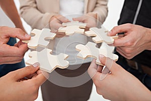 Businesspeople joining puzzle pieces