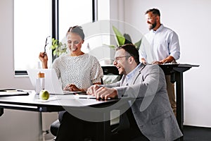 Businesspeople laughing together at work