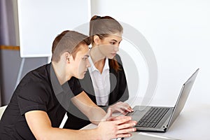 Businesspeople looking at computer screen