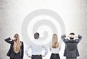 Businesspeople looking at concrete wall