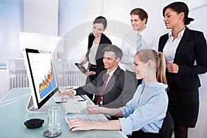 Businesspeople looking at graph on computer
