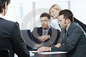 Businesspeople looking at laptop