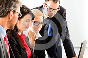 Businesspeople looking at laptop screen