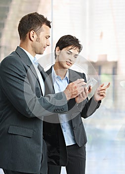 Businesspeople looking at smartphone