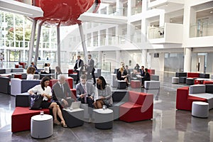 Businesspeople Meeting In Busy Lobby Of Modern Office photo