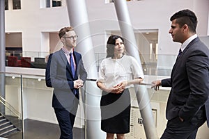 Businesspeople Meeting In Busy Lobby Of Modern Office