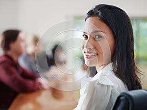 Businesspeople in meeting room and woman smiling