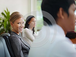Businesspeople in meeting room and woman smiling photo