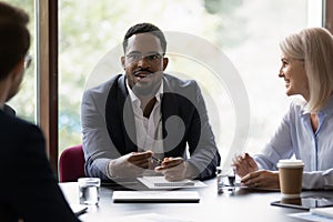 Businesspeople negotiating sit at desk focus on African businessman