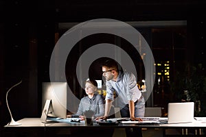 Businesspeople in the office at night working late.