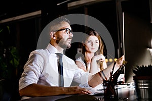 Businesspeople in the office at night working late.