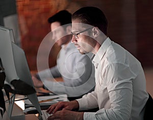 Businesspeople in the office at night working late