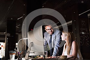 Businesspeople in the office at night working late.