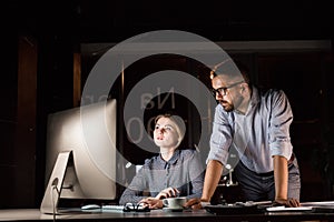 Businesspeople in the office at night working late.