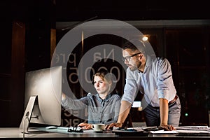 Businesspeople in the office at night working late.