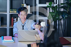 Businesspeople in the office at night working late, coffee and  calling phone working overtime together over a laptop at a desk in