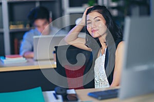 Businesspeople in the office at night working late, Two young businesspeople working overtime together over a laptop at a desk in