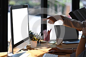 Businesspeople pointing on computer screen during discussing project together.