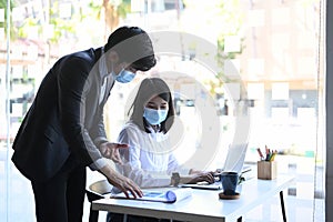 Businesspeople in protective mask are financial experts discussing information during accounting process .