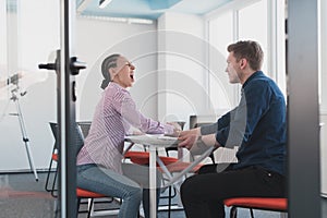 Businesspeople, rivalry and people concept - businesswoman and businessman arm wrestling during corporate meeting in