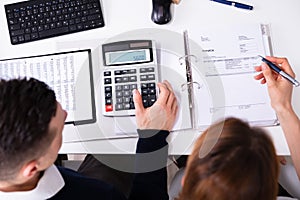 Businesspeople`s Hand Calculating Invoice With Calculator