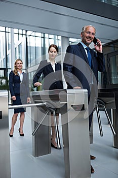 Businesspeople scanning their cards at turnstile gate