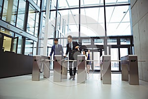 Businesspeople scanning their cards at turnstile gate