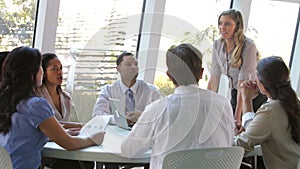 Businesspeople Seated Around Table Having Meeting