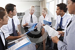 Businesspeople Seated In Circle At Company Seminar