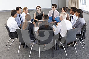 Businesspeople Seated In Circle At Company Seminar