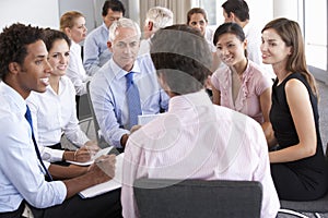 Businesspeople Seated In Circle At Company Seminar