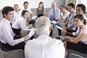 Businesspeople Seated In Circle At Company Seminar