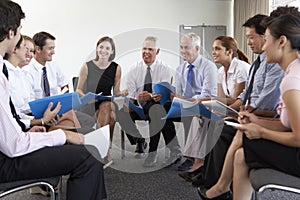 Businesspeople Seated In Circle At Company Seminar