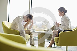 Businesspeople in serious discussion at office lobby photo