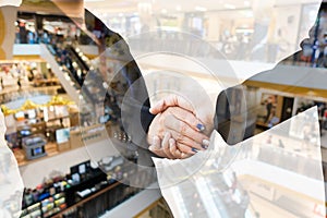 Businesspeople shaking hands with department store