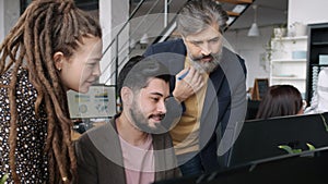 Businesspeople sharing ideas looking at computer screen brainstorming as team in office