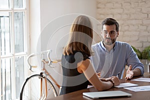 Businesspeople sit at desk discuss business ideas in office