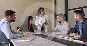 Businesspeople sit at desk shake hands, make deal
