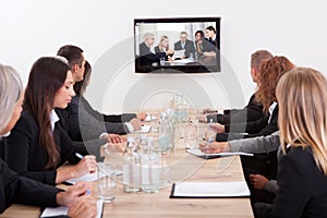 Businesspeople Sitting At Conference Table