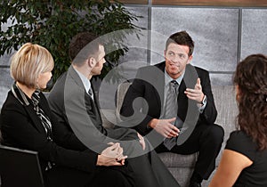 Businesspeople sitting on sofa, talking