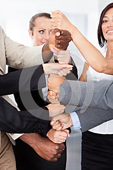 Businesspeople stacking fist over each other
