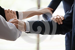 Businesspeople standing shoulder by shoulder showing unity closeup image