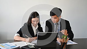 Businesspeople in suit sitting in office working with tablet computer and discussing new project.