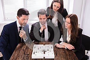 Businesspeople Trying To Solve Maze Puzzle