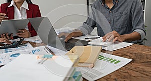 Businesspeople using a calculator to calculate numbers on a company& x27;s financial documents, analyzing financial data