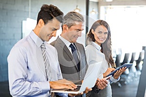 Businesspeople using mobile phone, lap top and digital tablet