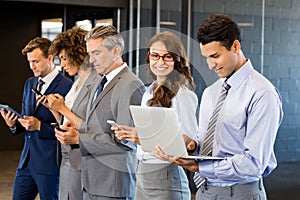 Businesspeople using mobile phone, lap top and digital tablet