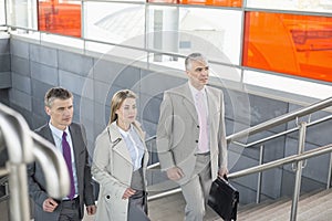 Businesspeople walking up stairs in train station