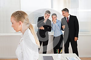 Businesspeople Whispering About Woman