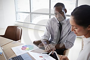 Businesspeople Working On Laptop In Boardroom Together